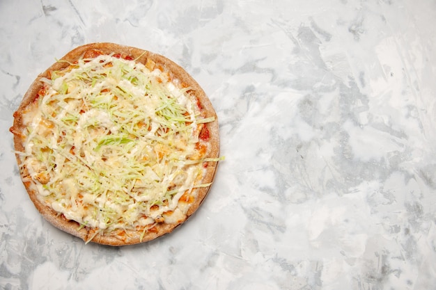 Vista dall'alto di una deliziosa pizza vegana fatta in casa sul lato destro sulla superficie bianca macchiata