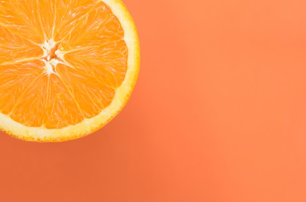 Vista dall&#39;alto di una fetta di frutta arancione su sfondo luminoso in colore arancione