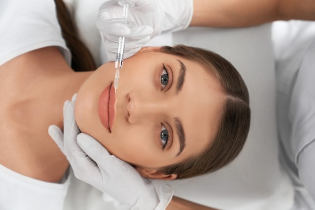 Vista dall'alto di una giovane donna attraente sulle labbra di aumento della procedura in estetista