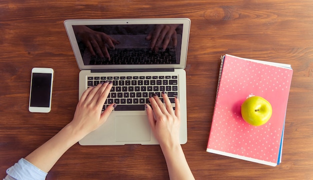 Vista dall'alto di una giovane donna d'affari che usa un laptop mentre lavora in ufficio ritagliata