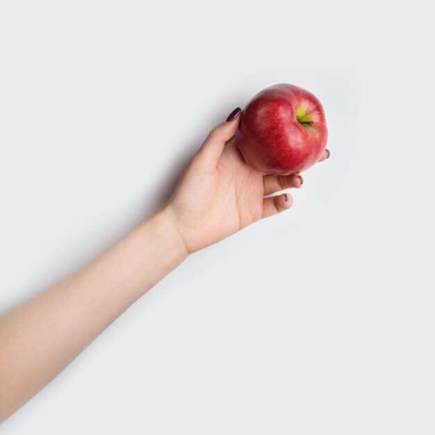 Vista dall'alto di una mano che tiene una mela rossa con copia spazio