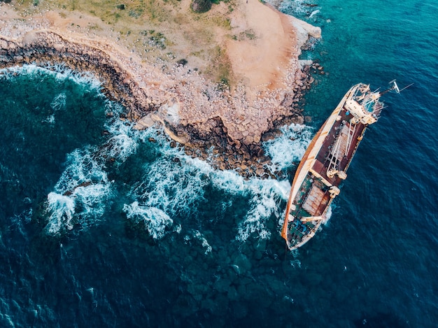 Vista dall'alto di una nave arenata vicino alla riva, ripresa da un drone.