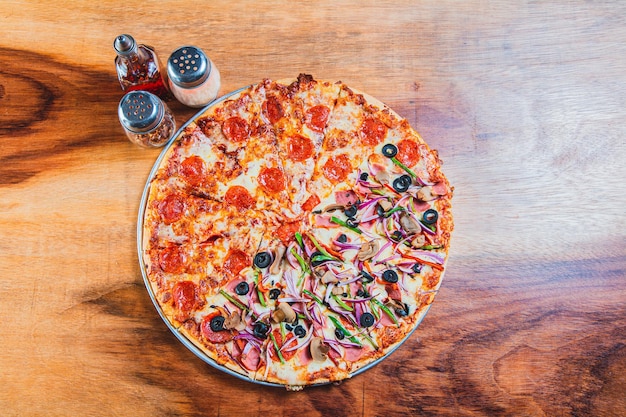 Vista dall'alto di una pizza mista suprema su un tavolo di legno Vista ad alto angolo di una Pizza mista suprema sulla tavola di legno