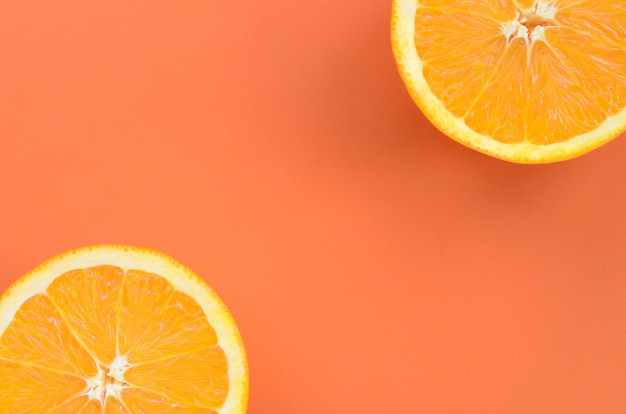 Vista dall&#39;alto di una serie di fette di frutta arancione su sfondo luminoso in colore arancione. Un&#39;immagine di trama di agrumi saturi