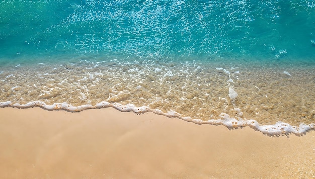 Vista dall'alto di una spiaggia tranquilla con il movimento del mare blu e delle onde sulla costa dell'oceano