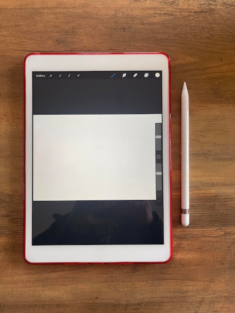Vista dall'alto di una tavoletta digitale e penna stilo sulla scrivania in legno