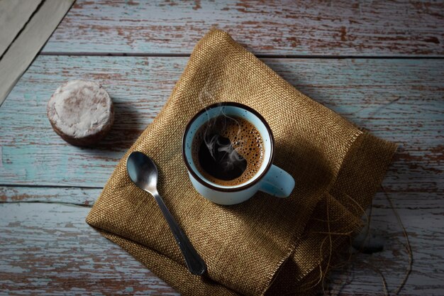 Vista dall'alto di una tazza di caffè aromatico con un biscotto fatto in casa e un giornale sul tavolo di legno Tempo di relax Atmosfera rilassata