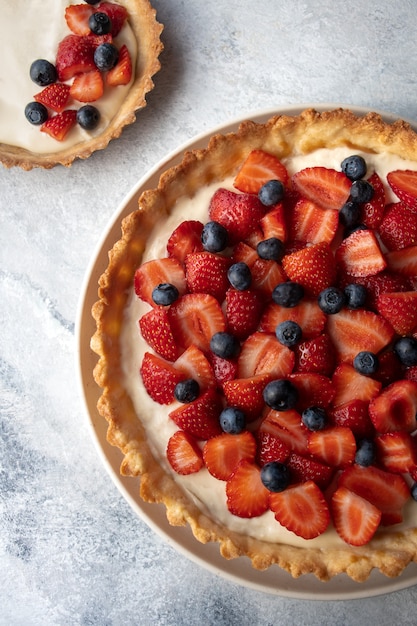 Vista dall'alto di una torta di crema di fragole e mirtilli