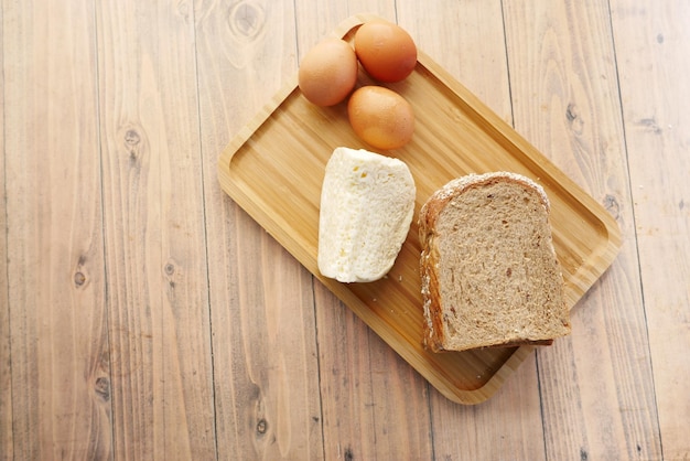 Vista dall'alto di uova di formaggio e pane integrale in un vassoio per alimenti