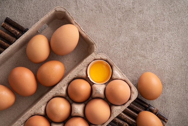 Vista dall'alto di uova di gallina marrone fresche in un piatto su sfondo grigio tavolo