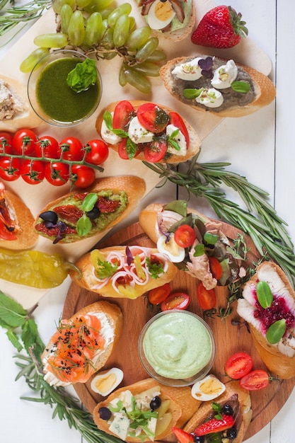 Vista dall'alto di varie bruschette con condimenti. Snack finger food per vino, antipasto italiano.