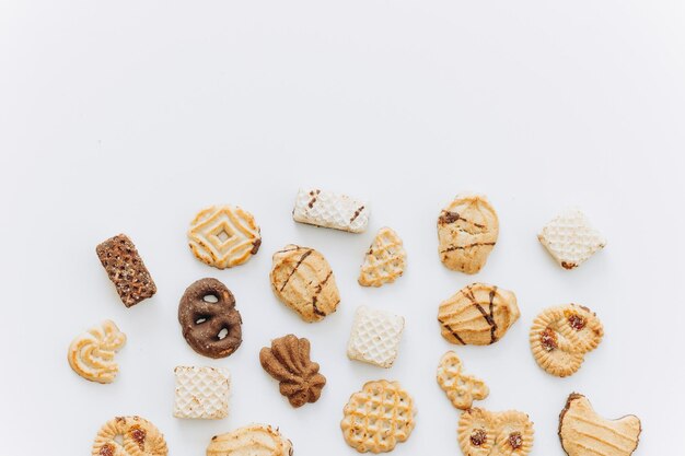 Vista dall'alto diversi cookie sul piano del tavolo Disposizione piatta di vari cookie su sfondo bianco