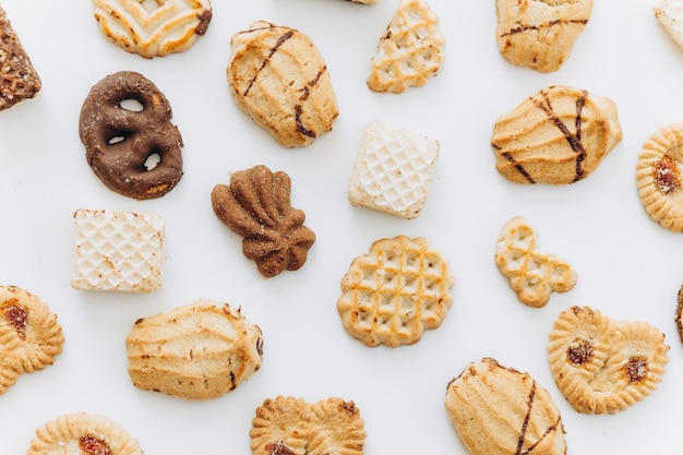 Vista dall'alto diversi cookie sul piano del tavolo Disposizione piatta di vari cookie su sfondo bianco