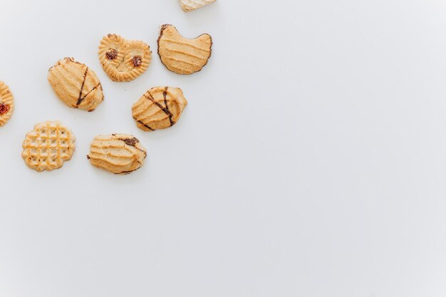 Vista dall'alto diversi cookie sul piano del tavolo Disposizione piatta di vari cookie su sfondo bianco