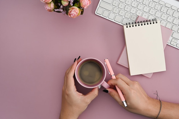 Vista dall'alto giovane donna che tiene una tazza di caffè sul posto di lavoro