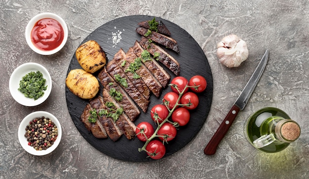 Vista dall'alto gustosa carne cotta con salsa sulla scrivania