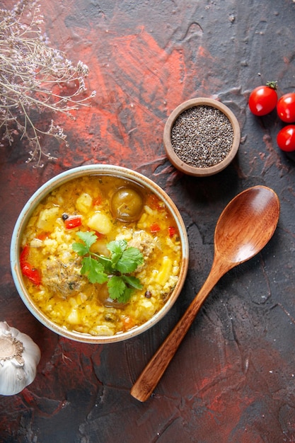 Vista dall'alto gustosa zuppa di carne con patate e riso all'interno di un piattino su superficie scura