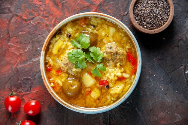 Vista dall'alto gustosa zuppa di carne con patate e riso all'interno di un piccolo piatto su superficie scura cibo insalata cucina ristorante pasto piatto da cucina