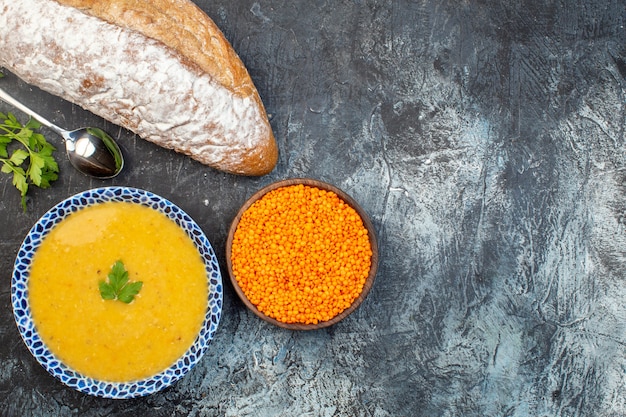 Vista dall'alto gustosa zuppa di lenticchie all'interno della piastra con pane su sfondo grigio cucina foto pasto cena pepe piatto colore vegetale