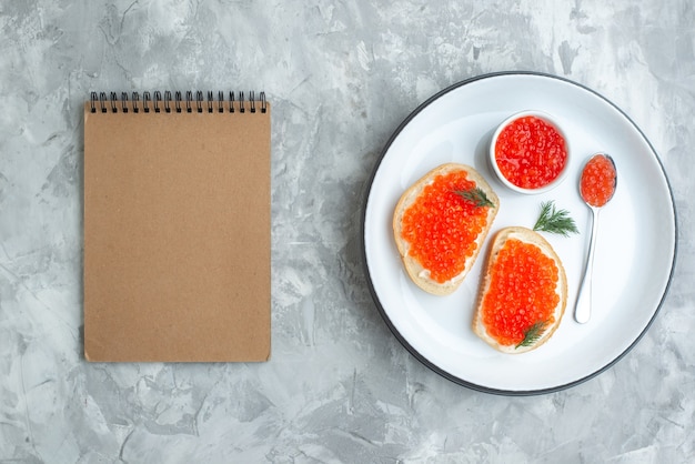 Vista dall'alto gustosi panini al caviale all'interno della piastra sulla superficie bianca snack piatto di pesce toast a base di pesce cena pasto colazione