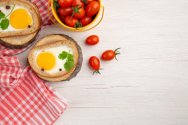 Vista dall'alto gustosi toast all'uovo con pomodori su sfondo bianco colazione insalata cibo foto pasto colore pranzo