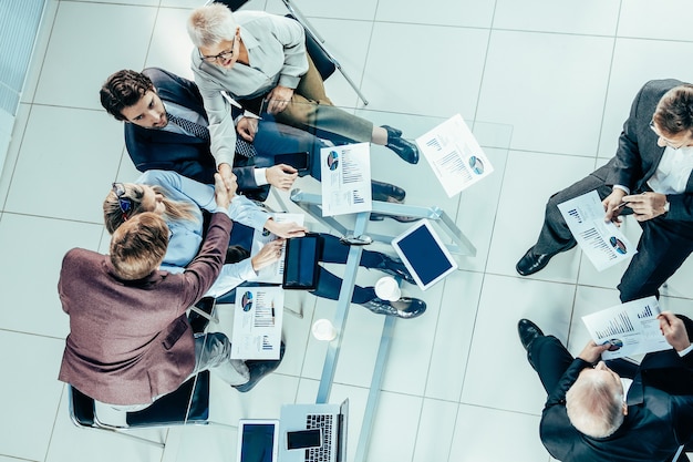 Vista dall'alto. il gruppo di lavoro sta lavorando alla relazione finanziaria. concetto di affari.