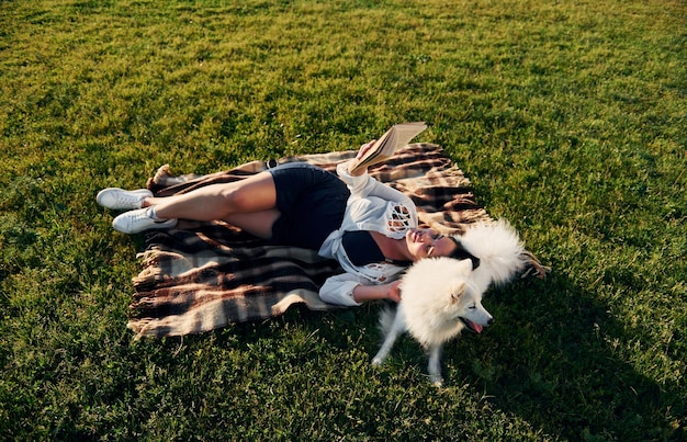 Vista dall'alto La donna con il suo cane si diverte sul campo durante la giornata di sole