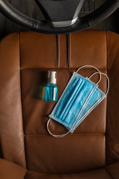 Vista dall'alto Maschera medica Alcool Gel disinfettante per le mani sul seggiolino auto.