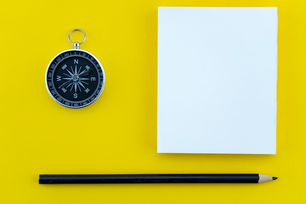 Vista dall'alto oggetti aziendali di carta bianca, matita e bussola su carta lavoro sfondo giallo Composizione piatta laici.