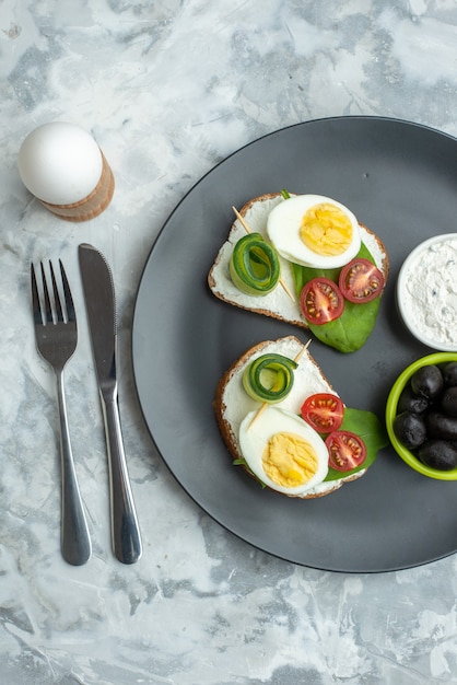 Vista dall'alto panini all'uovo all'interno della piastra con olive su sfondo bianco dieta sandwich salute burger pane pranzo cibo toast