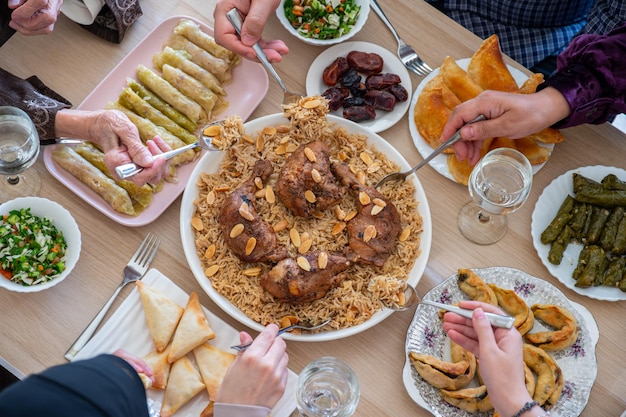 Vista dall'alto per una famiglia araba che cena insieme su un tavolo di legno con il padre, la madre, il nonno, la nonna e il figlio