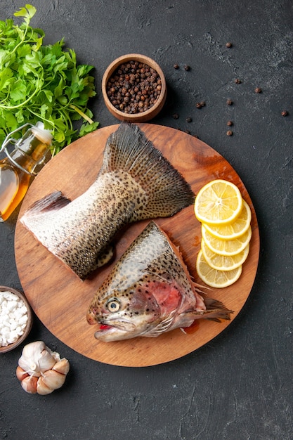 vista dall'alto pesce fresco a fette con fettine di limone sullo sfondo scuro pasto a base di frutti di mare pasto di cibo dell'oceano insalata pesce d'acqua carne di mare