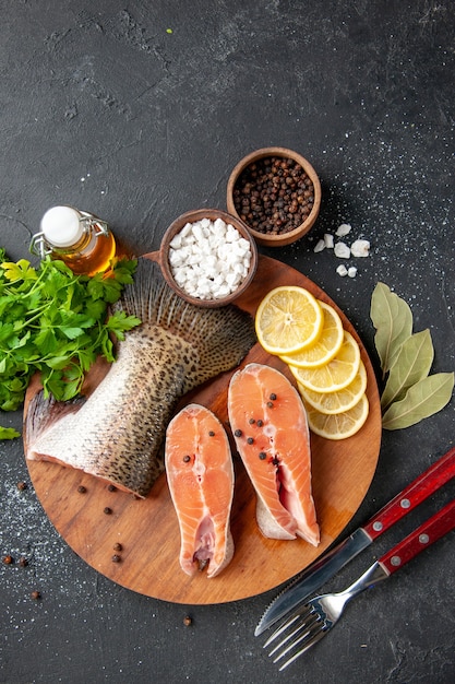 vista dall'alto pesce fresco con fettine di limone e condimenti su sfondo scuro pasto a base di frutti di mare cibo pasto acqua pesce carne insalata oceanica mare