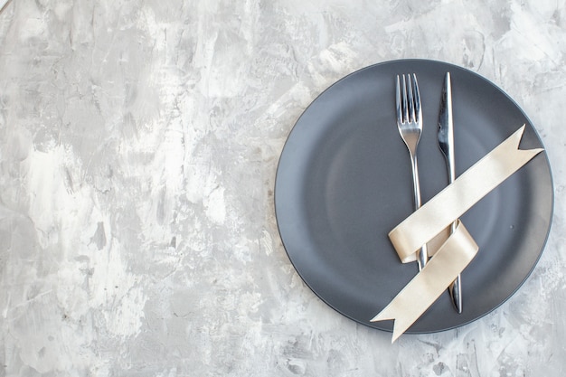 vista dall'alto piatto scuro con forchetta e coltello su superficie chiara cucina signore orizzontale pasto colore vetro femminilità