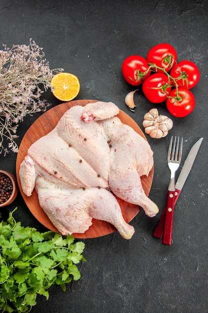 vista dall'alto pollo crudo fresco con verdure e pomodori rossi