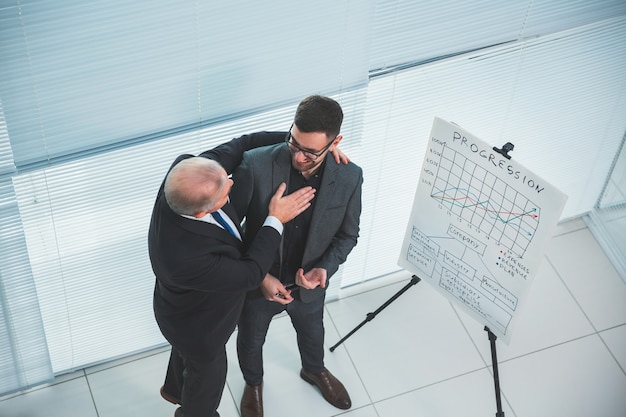 Vista dall'alto. Project Manager si congratula con il dipendente per una presentazione di successo