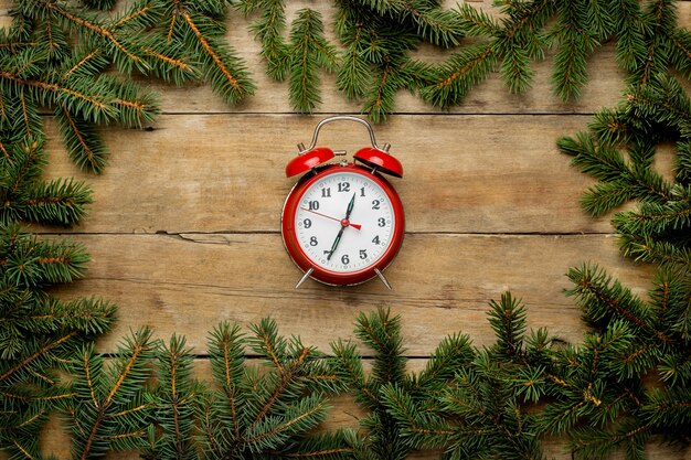 vista dall'alto Rami di albero di Natale sulla tavola di legno con orologio