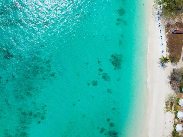Vista dall'alto Spiaggia colorata onde superficie del mare riva del mare Incredibili onde che si infrangono sulla spiaggia sabbiosaBellissima spiaggia di sabbiaNatura e sfondo di viaggio