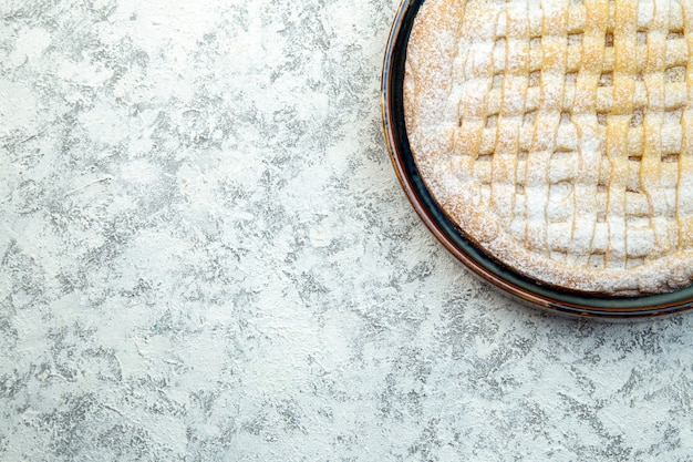 Vista dall'alto squisita torta dolce zucchero in polvere all'interno della padella su sfondo bianco biscotti torta pasticceria cuocere zucchero biscotto tè