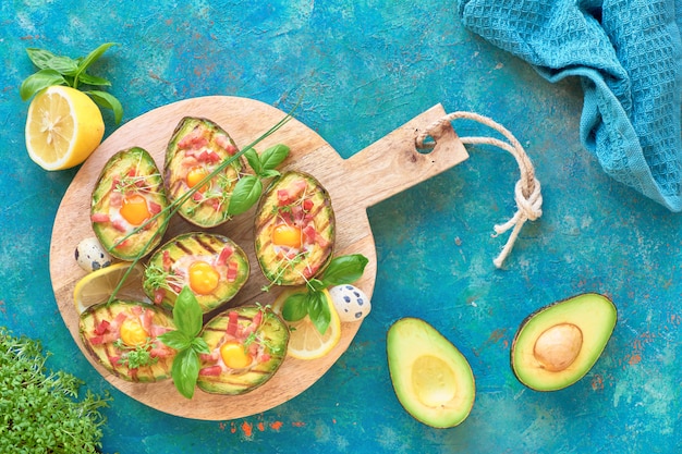 Vista dall'alto su barche di avocado alla griglia con pancetta e uova