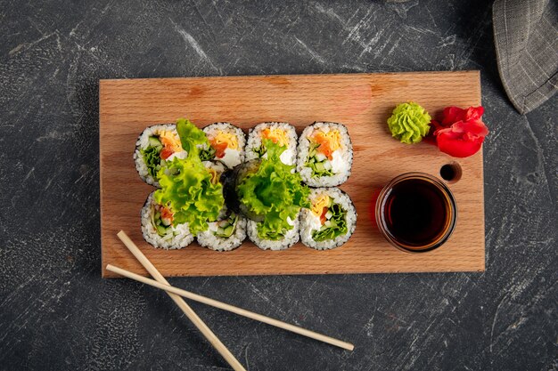 Vista dall'alto sul gimbap di involtini di riso alle alghe sulla tavola di legno con salsa di soia