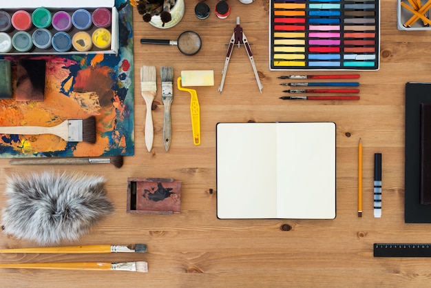 Vista dall'alto sul posto di lavoro del pittore. Tavolo in legno di un artista con strumenti artistici per disegnare.