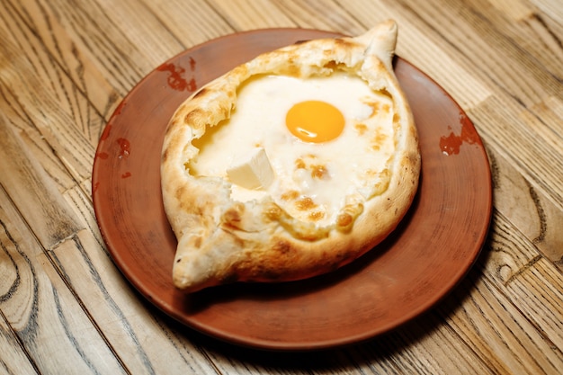 Vista dall'alto sul tradizionale Khachapuri Adjarian - torta al forno aperta con formaggio sale fuso suluguni