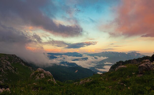 Vista dall'alto sulla valle di montagna coperta di nuvole al tramonto Lagonaki Caucaso Russia