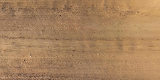 Vista dall'alto sulle tracce di pneumatici per auto sulla struttura della strada sterrata