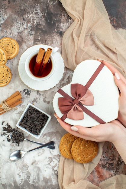 Vista dall'alto tazza di tè con biscotti dolci e presente su sfondo chiaro coppia di San Valentino sensazione di zucchero biscotto amore matrimonio