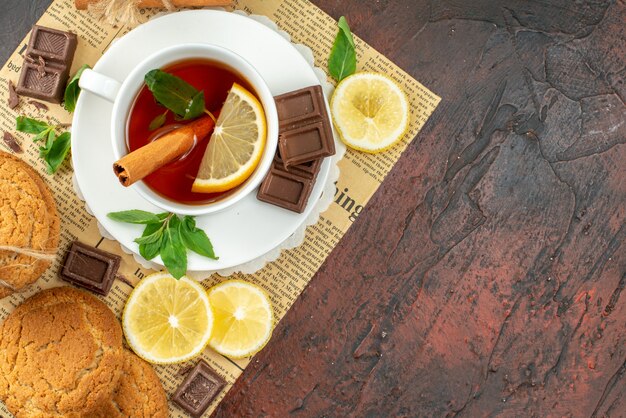 vista dall'alto tazza di tè con limoni gialli freschi e biscotti su sfondo scuro mattina dolce cerimonia del colore colazione tè alla frutta