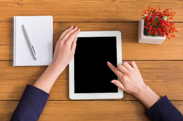 Vista dall'alto touch screen donna d'affari del tablet in ufficio. Libero professionista che lavora con un computer portatile con spazio di copia sul display