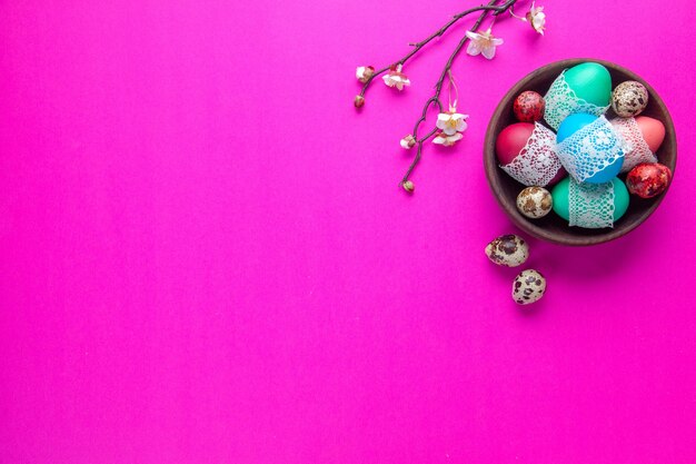 vista dall'alto uova colorate all'interno della piastra sulla superficie rosa concetto vacanza primaverile Novruz etnico colorato