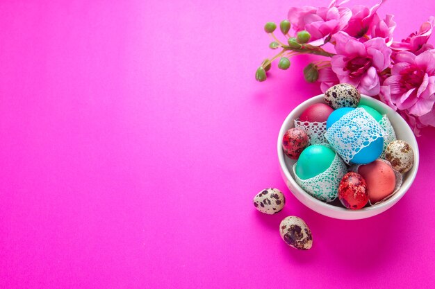 vista dall'alto uova colorate all'interno della piastra sulla superficie rosa ornato concetto etnico di vacanza primavera colorato